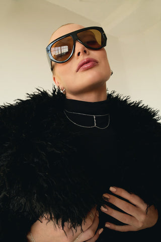 Woman wearing a furry jacket, oversized sunglasses, and black mockneck top showing the sterling silver Julia choker. 