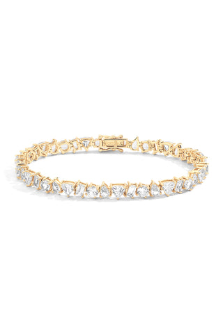 A front view of a clasped gold tennis bracelet featuring alternating prong-set pear, trillion, round, and baguette shaped lab grown sapphires with a double latch security clasp against a white background. 