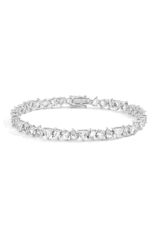 A front view of a clasped tennis bracelet featuring alternating prong-set pear, trillion, round, and baguette shaped lab grown sapphires with a double latch security clasp against a white background. 