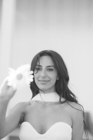 Black and white photo of a woman holding a flower