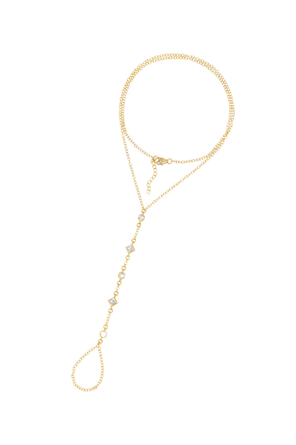 Gold hand chain featuring crystal drop accents, a bracelet connected to a finger ring by chains, and an adjustable clasp closure on a white background.