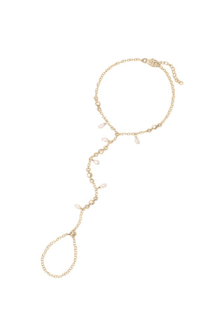 A delicate gold hand chain featuring small dangling pearls beads, displayed on a clean white background.
