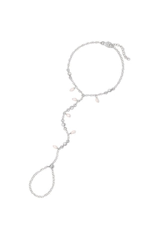 A delicate silver hand chain with alternating pearls and CZs, with an adjustable bead at the finger. shown on a plain white background.
