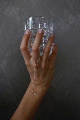 Ariella hand chain in silver on model with cup in hand perfect waterproof hand chain for gifting