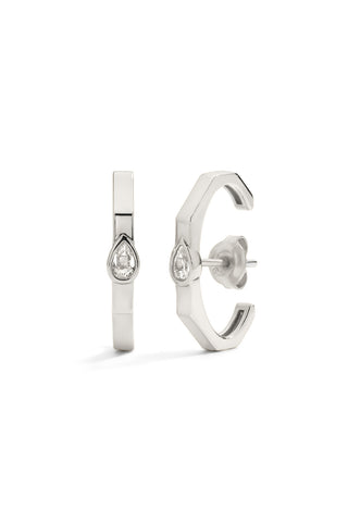 Pair of silver hoop earrings in the shape of an angular ear cuff with pear-shaped lab grown sapphires on a white background