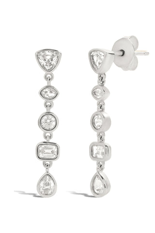 Pair of silver earrings with bezel set white sapphires on a white background