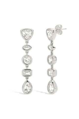 Pair of silver tennis earrings with alternating shaped lab grown sapphires in marquise, pear, round, and baguette shapes on a white background