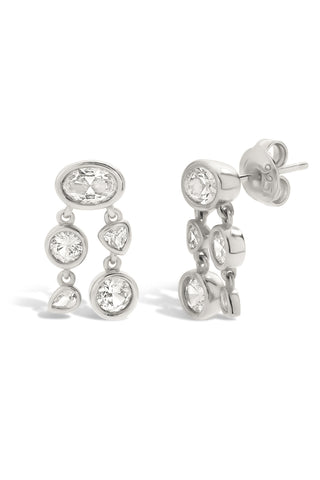 Pair of sterling silver clustered bezel set earrings with white sapphire on a white background