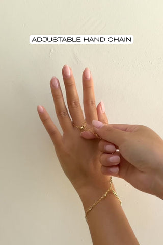 video of gold hand chain being adjusted to fit the finger