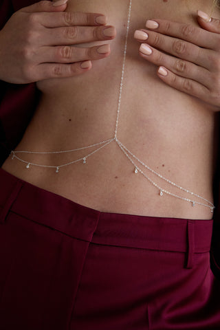 Detail shot of a silver body chain on a woman's torso 