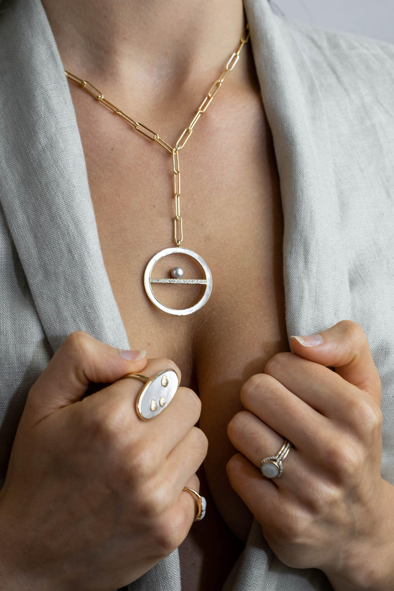 Model with Cher 14K solid gold and mother of pearl medallion
